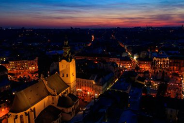 Ukrayna, Lviv 'deki Aydınlatılmış Latin Katedrali ve Rynok Meydanı' nın gece görüşü. Lviv belediye binasından görüntü