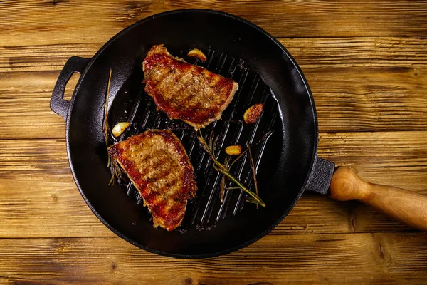 Grillade Fläskbiffar Med Rosmarin Vitlök Och Kryddor Stekpanna Gjutjärn Träbord — Stockfoto