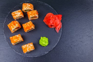 Suşi Philadelphia 'yı siyah bir levhada yuvarlıyor. Üst görünüm