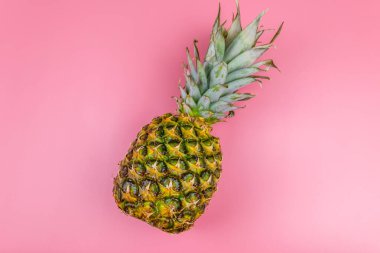Pembe arka planda koca bir ananas. Üst görünüm