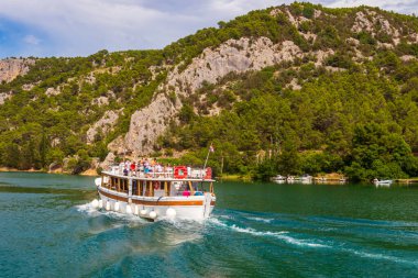 Skradin, Hırvatistan - 27 Haziran 2024: Hırvatistan 'ın Krka Ulusal Parkı' ndaki Krka nehri üzerinde seyahat eden turizm gemisi