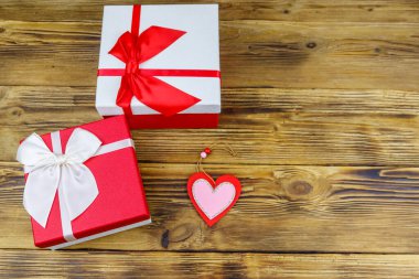 Ahşap arka planda hediye kutuları ve kırmızı kalp. Sevgililer Günü konsepti