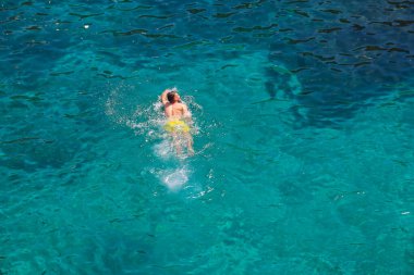 Marsaxlokk, Malta - 18 Mayıs 2025: Akdeniz 'de yüzen bir adamın üst görüntüsü.