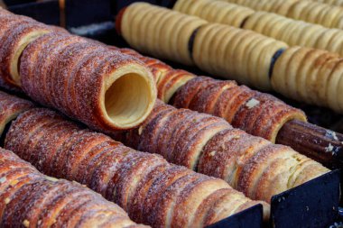 Geleneksel czech huni keklerinden trdelnik kömür üzerinde pişirilmiş dönen silindirlerde yapılır. Prag 'da sokak yemekleri, Çek Cumhuriyeti