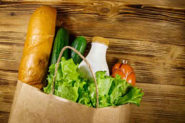 Tahta masa üzerinde farklı yiyecekler olan kağıt torba. Üst Manzara. Market alışverişi kavramı