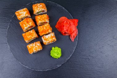 Suşi Philadelphia 'yı siyah bir levhada yuvarlıyor. Üst görünüm