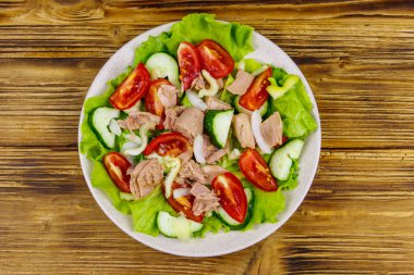 Marullu lezzetli ton balığı salatası ve ahşap masada taze sebzeler. Üst görünüm
