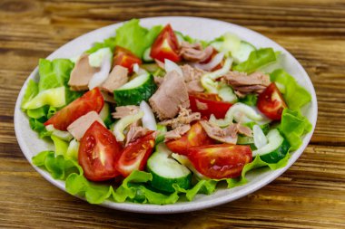 Marullu lezzetli ton balığı salatası ve ahşap masada taze sebzeler.