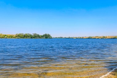Güzel bir nehir, yeşil ağaçlar ve mavi gökyüzü olan yaz manzarası