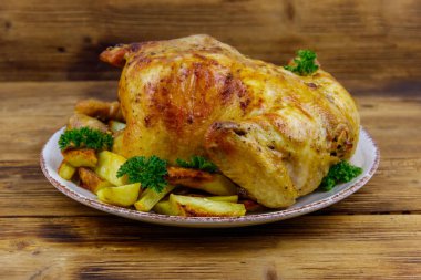 Ahşap bir masada bütün tavuğu patates ile pişirdim.