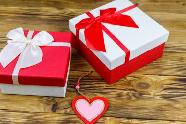 Ahşap arka planda hediye kutuları ve kırmızı kalp. Sevgililer Günü konsepti