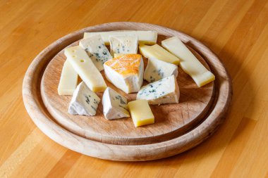 Tahta masada farklı peynirler bulunan peynir tabağı.