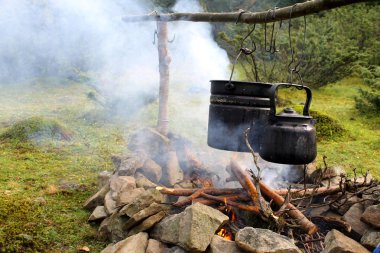Tencere ve çaydanlık kamp ateşi üzerinde