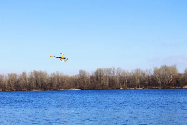 Helikopter over de rivier — Stockfoto