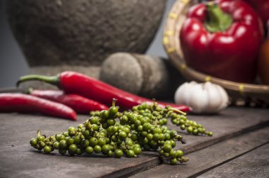 fresh pepper and garlic with mortar on wooden table