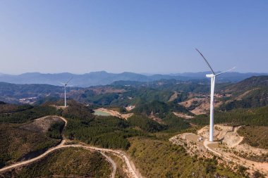 Dağdaki rüzgar türbininin havadan çekilmiş fotoğrafı.