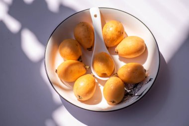 Güneşin altındaki tabakta loquats