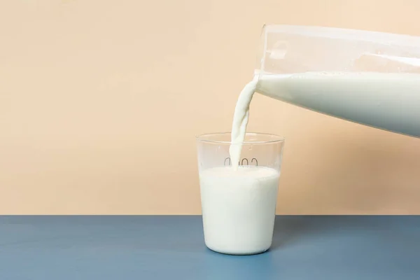 Pour milk into a glass from a large glass milk bottle