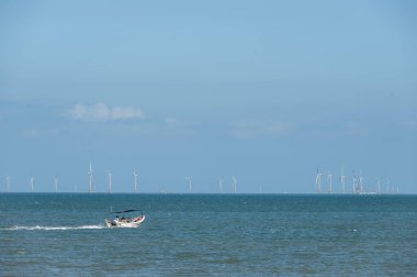 Yazın güneşli bir günde, sürat teknesi mavi denizde hızlı sürdü.