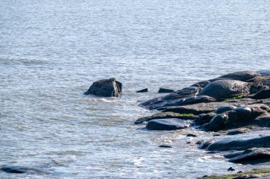 Alacakaranlıkta, sahildeki deniz kayaları tokatladı.