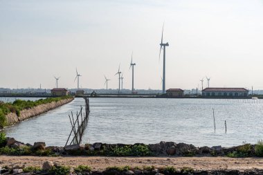 Mavi gökyüzünün altında kıyı şeridi rüzgar türbini
