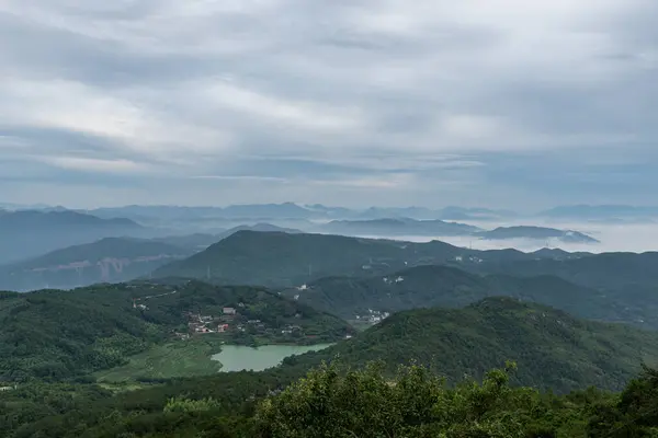 stock image Early in the morning, peaks in the fog, fields and villages.