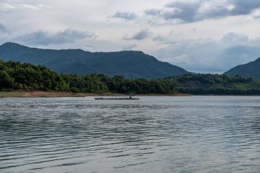 Gökyüzü bulutlarla kaplı ve suyun üzerinde dalgalar var.