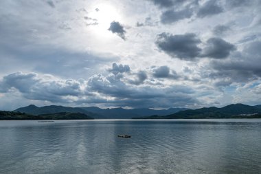 Gökyüzü bulutlarla kaplı ve suyun üzerinde dalgalar var.