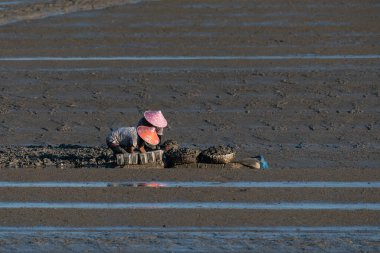 Siyah sahilde çalışan iki balıkçı.