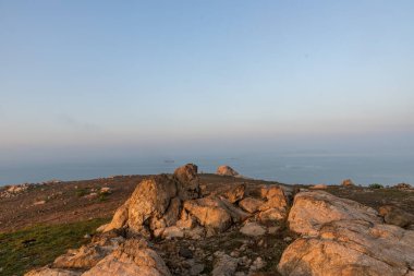 Kamp adasının erken saatlerinde kayalar ve güneş ışığı güzel bir manzara oluşturur.