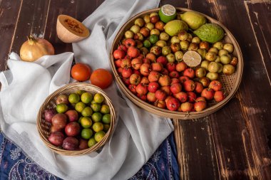Birçok renk ve meyve çeşidi tabakta ya da ahşap masaya saçılmıştır.