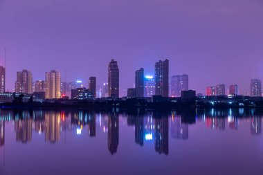 Geceleri gölün kenarında yansıyan bir şehir.