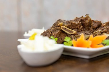 Et tabağı ahşap masadaki tabakta.