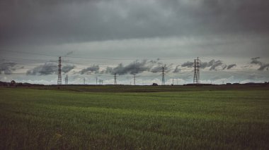 Çayırların ve elektrik hatlarının üzerinde kasvetli bir gökyüzü
