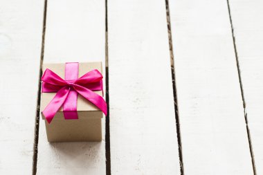 Noel hediyesi Beyaz ahşap zemin üzerinde pembe kurdele ile