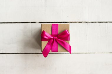 Noel hediyesi Beyaz ahşap zemin üzerinde pembe kurdele ile