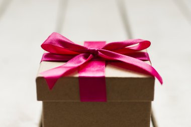 Noel hediyesi Beyaz ahşap zemin üzerinde pembe kurdele ile yakın çekim