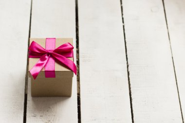 Noel hediyesi Beyaz ahşap zemin üzerinde pembe kurdele ile