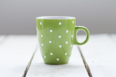 Ahşap arka plan üzerinde beyaz noktalı yeşil Kupası