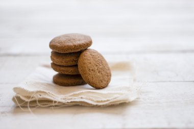 Ahşap masa üzerinde beyaz keten peçete çerezleri