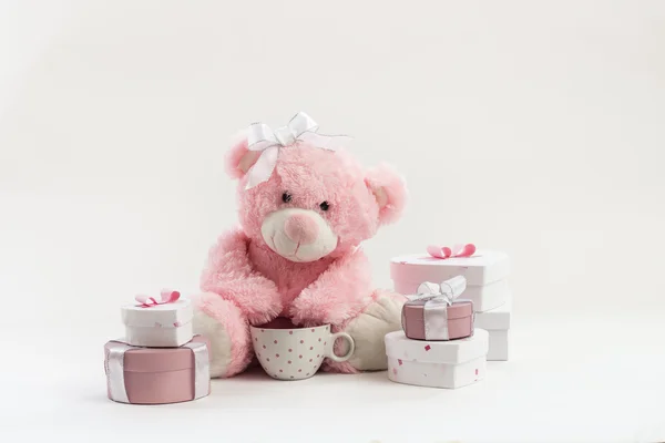 Розовый плюшевый мишка на белом с подарками — стоковое фото