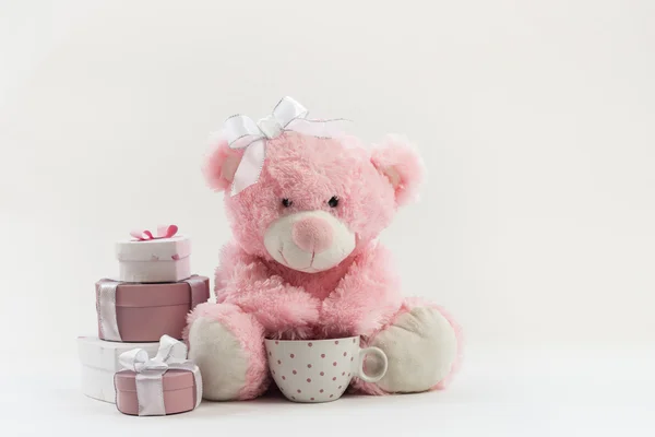 Розовый плюшевый мишка на белом с подарками — стоковое фото