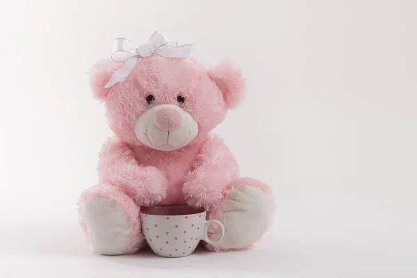 Ροζ αρκουδάκι σε άσπρο φόντο ξύλινη με ένα φλυτζάνι τσάι — Φωτογραφία Αρχείου
