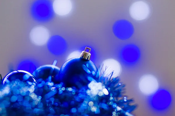 Blue christmas balls in a white wooden box and christmas lamps in the background — Stock Photo, Image