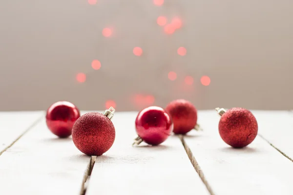 Красные рождественские шары на деревянном фоне и красные лампы на заднем плане Лицензионные Стоковые Фото