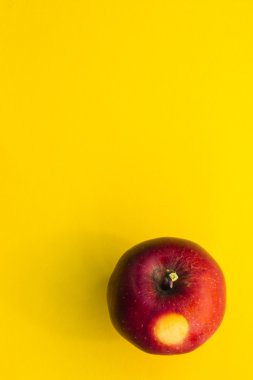 Sarı arkaplanda kırmızı elma,