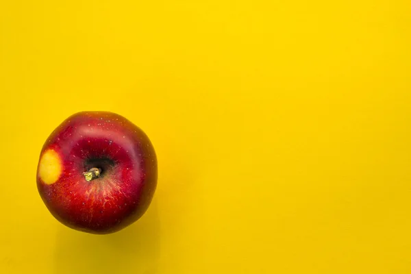 Red apple on yellow background — Stock Photo, Image