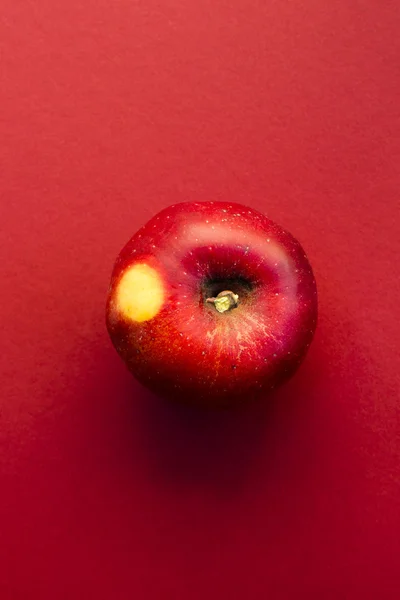Красное яблоко на красном фоне Лицензионные Стоковые Изображения