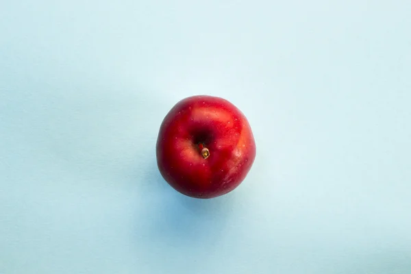 Красное яблоко на голубом фоне Лицензионные Стоковые Фото