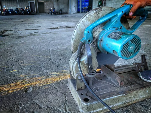 웨어의 라이트 이미지노란 헬멧은 기계를 사용하여 무릎을 꿇는다 공장이나 차고에서 — 스톡 사진